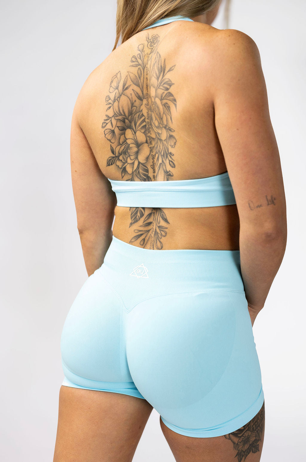 Back view of aqua sculpt halter bra showing open back design with matching aqua shorts