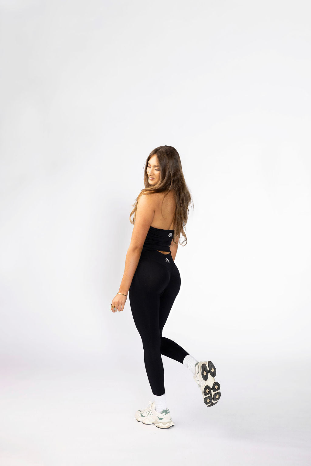 Side view of sculpt leggings displaying high-compression waistband and second-skin fit. Paired with matching halter top with open back