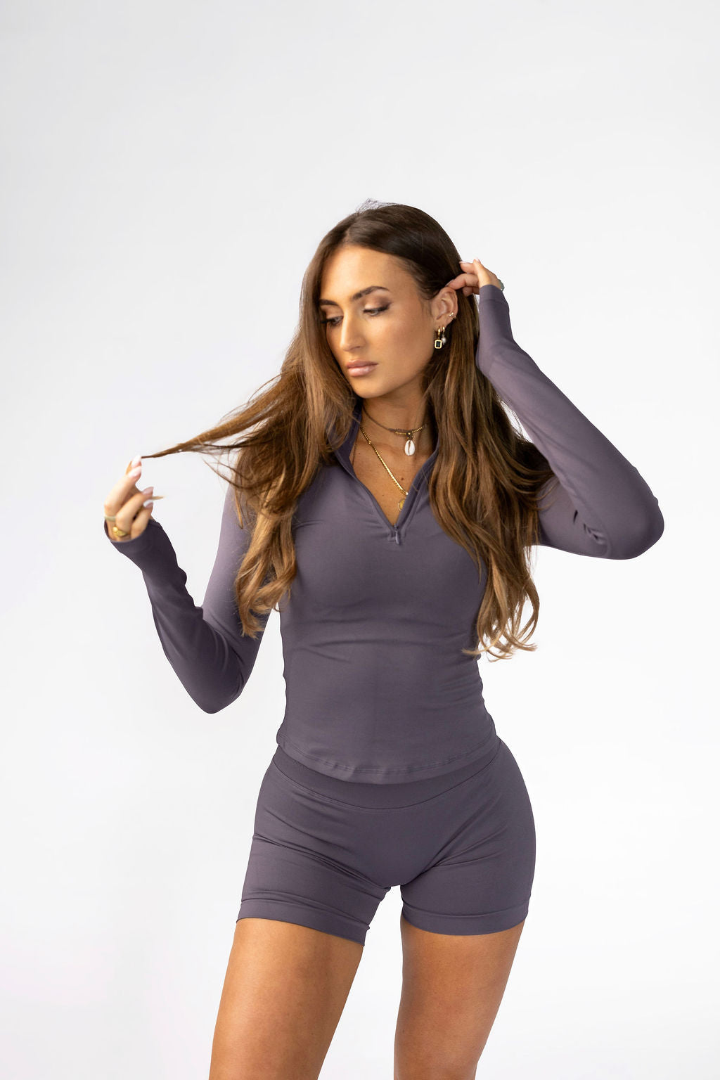 Quarter zip jacket partially zipped showing versatile styling options.
Extended sleeves with thumb holes on quarter zip activewear jacket